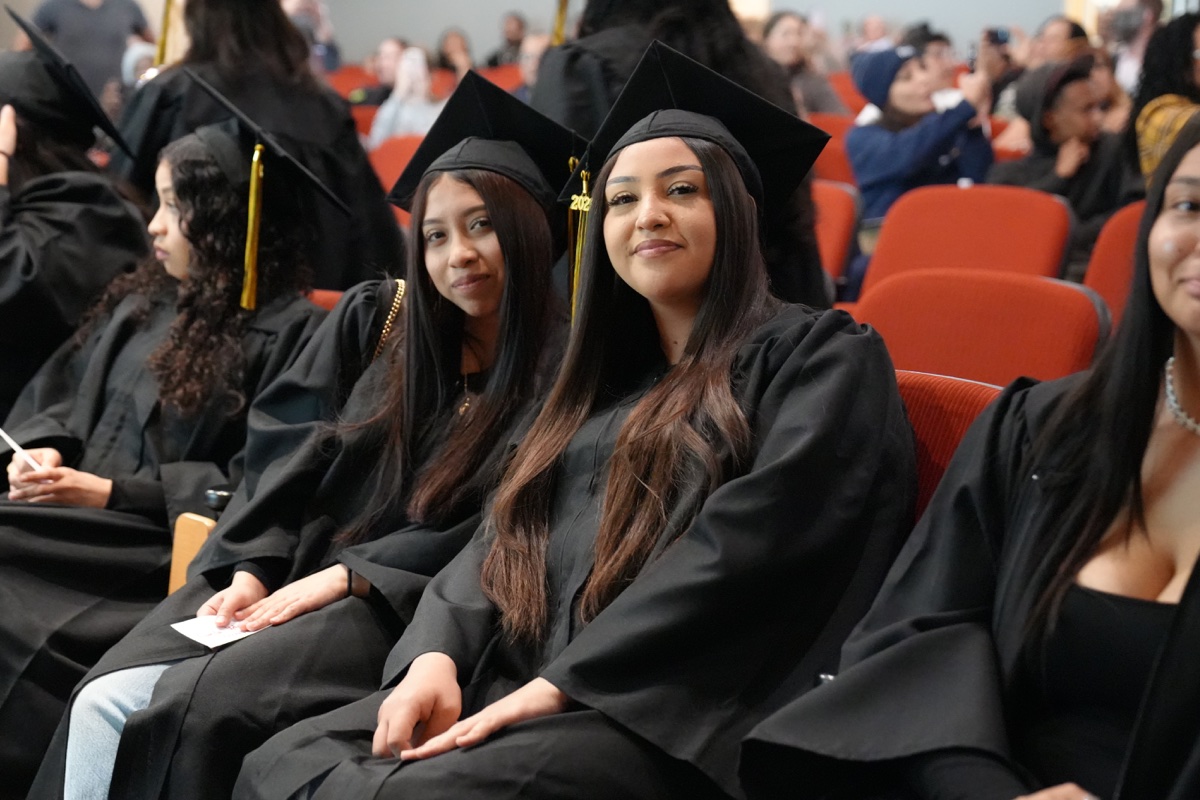 Two OakTown Leaders graduates smiling in caps and gowns at their graduation ceremony